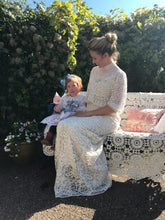 A Mother and child in edwardian dresses from days of Grace Vintage. The child is dressed in a Broderie Anglais dress with a blue satin alice band, just like a little Alice in Wonderland