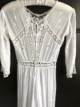 The back view of an edwardian lace dress, showing the tape fastenings and fine lace detailing 