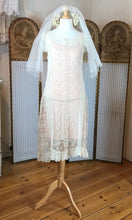 a front on shot of a stunning lace nineteen twenties wedding dress with a dropped waist 