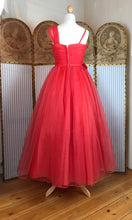 The back view of a red 1950's ball gown with a full, long skirt 
