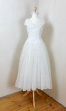 A simple yet elegant ivory wedding dress with a full circle skirt , original 1950's vintage dress
