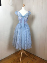 An elegant bow detail graces the back of an original 1950's pale blue prom dress with a nipped in waist and circle skirt