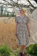 Our model wears a forties print dress with flat boots and a yellow headscarf - true forties fashion!