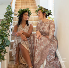 An English country house wedding scene showing two girls in green leaf crowns and vintage lace wedding dresses sat on the sweeping stairs of a charming country house. Country wedding inspiration  