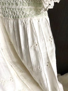 Close up of the hand made lace backed with pale green silk on the waistband of a white Edwardian dress made from cotton lawn