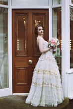 A vintage bride in a strapless lace gown with a boned bodice and full length frilled lace skirt 